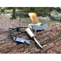 Origin Outdoors Zuendstahl Deluxe fuer Outdoor auf Baumstamm liegend vor dem Feuer